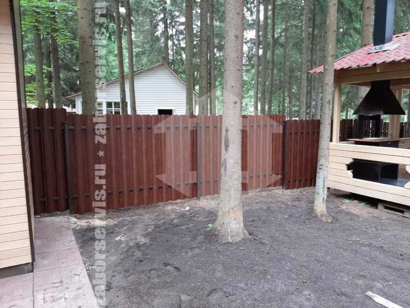 Забор из металлического штакетника на фундаменте под дерево